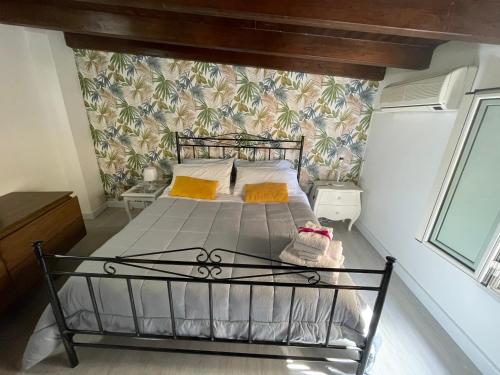 sypialnia z łóżkiem w pokoju ze ścianą w obiekcie La Zisa Holiday w mieście Palermo