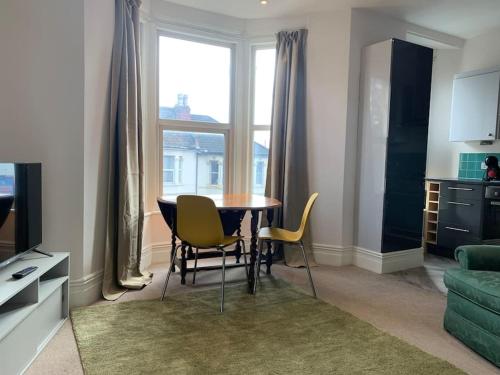 a living room with a table and chairs and a window at Central 2 bed flat. Free parking (Off-street) in Bristol