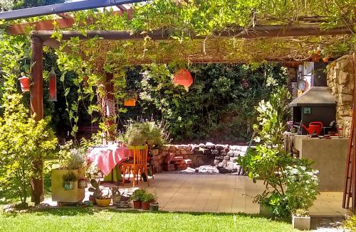 pérgola con mesa y sillas en un jardín en Hermosa casa en barrio parque. en Mar del Plata