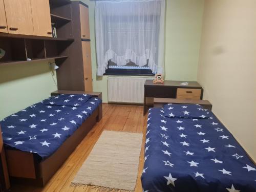 a room with two beds and a desk and a window at Skala in Rečica ob Savinji