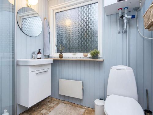 ein Badezimmer mit einem WC, einem Waschbecken und einem Spiegel in der Unterkunft Holiday Home Hesselhus in Abildskov