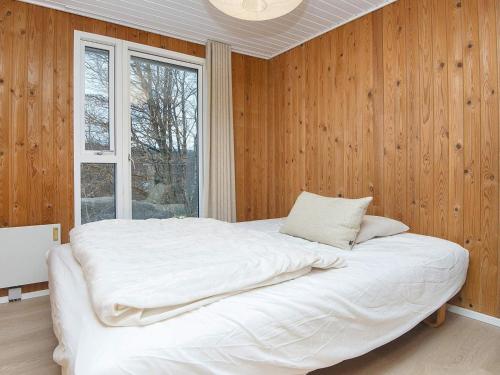 ein großes Bett in einem Zimmer mit Fenster in der Unterkunft Holiday Home Hesselhus in Abildskov