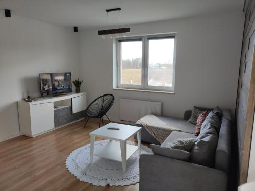 a living room with a couch and a table at Ustronny Zakątek in Ustroń