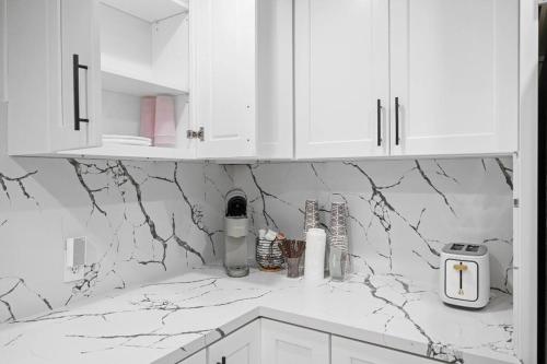 a white kitchen with marble counter tops and white cabinets at Universal studios getaway in Los Angeles