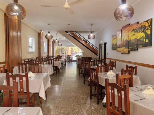 a dining room with white tables and wooden chairs at Hotel La Toscana in Villa Carlos Paz