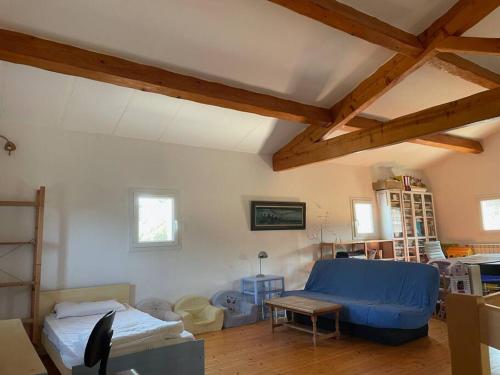 un salon avec un canapé bleu et une table dans l'établissement Mes vacances dans la garrigue, à Vacquières