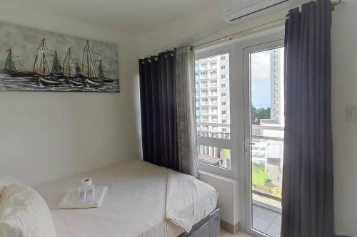 a bedroom with a bed and a large window at C&C Cool View Tagaytay Staycation in Tagaytay
