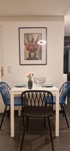 a white table with two chairs and a vase with flowers at House - Sunlit haven with outdoor terrace, garage and metro 14, RER B in Gentilly