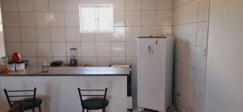 a kitchen with a counter and a white refrigerator at Apartamento Vila Aconchego Vermelho in Salvador