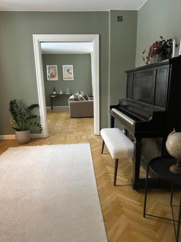Prästgården في Norberg: غرفة معيشة بها بيانو وأريكة