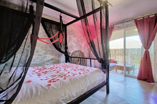 um quarto com uma cama com flores vermelhas em love room avec spa et piscine vu panoramique em Solliès-Toucas