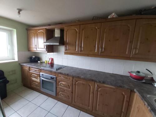 a kitchen with wooden cabinets and a stove top oven at Essex Riverside in Grays Thurrock