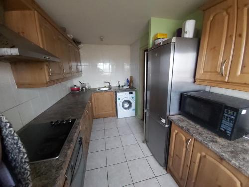 a kitchen with a refrigerator and a washing machine at Essex Riverside in Grays Thurrock