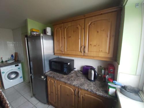 a kitchen with a refrigerator and a microwave at Essex Riverside in Grays Thurrock