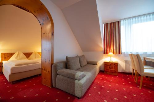 Habitación de hotel con cama y silla en Pension & Apartments Ertl en Seeboden