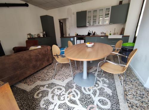 sala de estar con mesa, sillas y sofá en Casa Valduggia en Valduggia