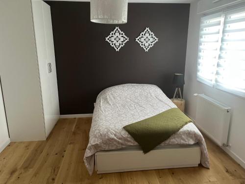 - une chambre avec un lit et un mur noir dans l'établissement Superbe Maison avec jardin, à Bezannes