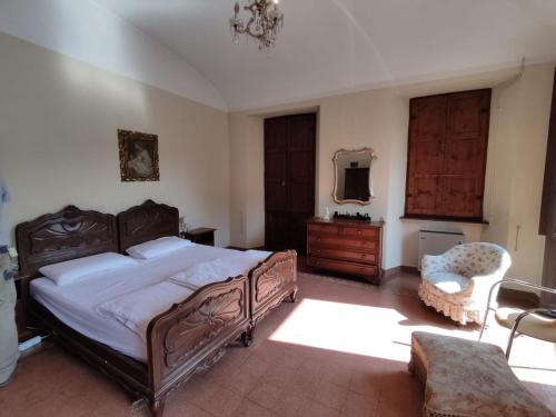 a bedroom with a large bed and a chair at Casa Valduggia in Valduggia