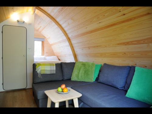 a living room with a blue couch and a table at South Kerry Glamping in Cahersiveen