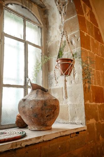 a vase sitting on a ledge next to a window at Jordan Heritage Madhafa in Al Salt