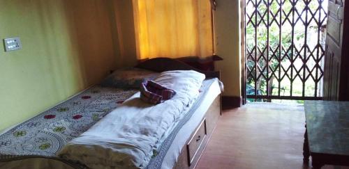バンディプールにあるGARIMA HOMESTAYの窓付きの客室の小さなベッド1台分です。