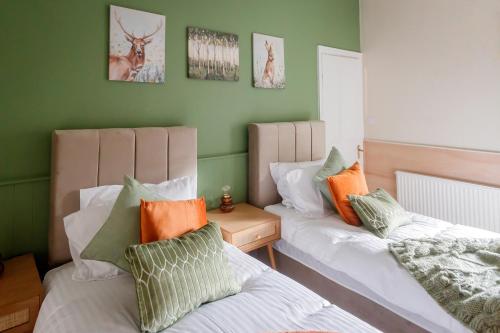 2 camas en una habitación con paredes verdes en The Green House 3 Bed House - Families, Contractors, Free Parking, close to racecourse and city centre en Doncaster