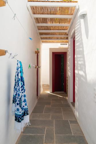 a hallway with white walls and a red door at Stunning Sunset House on Kamares Bay with Playground in Kamarai