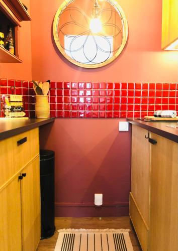 - une cuisine avec du carrelage rouge sur le mur dans l'établissement Les Mouettes, à Trouville-sur-Mer