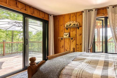 a bedroom with a bed and a large window at Luxurious log cabin with private spa in Lac-Superieur