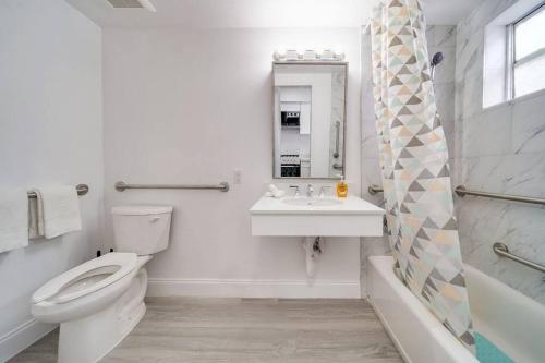 ein Badezimmer mit einem WC, einem Waschbecken und einem Spiegel in der Unterkunft Ocean Drive Prime Apt w/2 QueenBeds & Washer/Dryer in Miami Beach