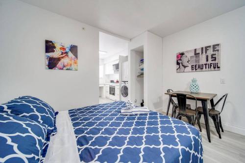 Schlafzimmer mit einem blauen und weißen Bett und einem Tisch in der Unterkunft Ocean Drive Prime Apt w/2 QueenBeds & Washer/Dryer in Miami Beach