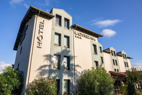 a building with a sign on the side of it at Hotel Loreak in Bayonne