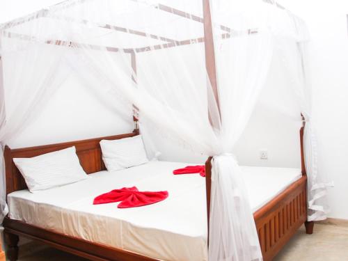 - une chambre avec 2 lits avec des archets rouges dans l'établissement Saimon Villa, à Mirissa