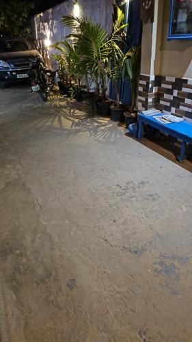 a parking lot with a blue bench in front of a building at Dream Vision Guest House in Diu