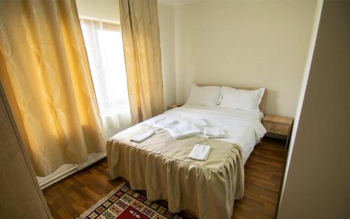 a white bed in a room with a window at Casa Vădeanu in Sighetu Marmaţiei