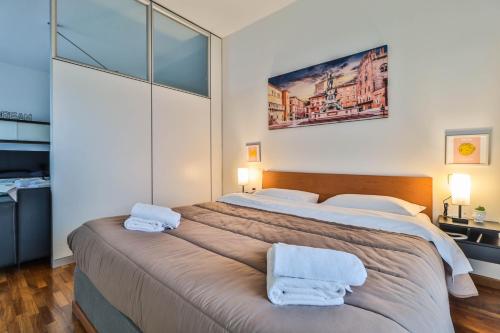1 dormitorio con 1 cama grande y 2 toallas. en Masini House [Bologna Station-Center-Fiera], en Bolonia