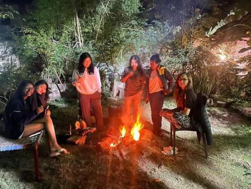 Eine Gruppe von Frauen steht um ein Feuer herum in der Unterkunft Dream Vision Guest House in Diu