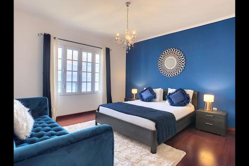 a blue bedroom with a bed and a blue wall at Casa Eleanor by LovelyStay in Calheta