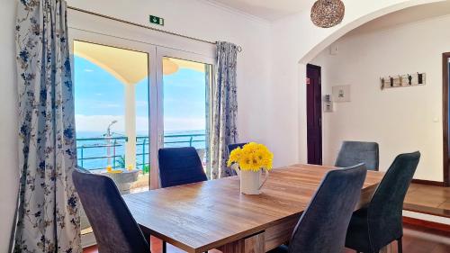 a dining room with a table and chairs and a window at Casa Eleanor by LovelyStay in Calheta