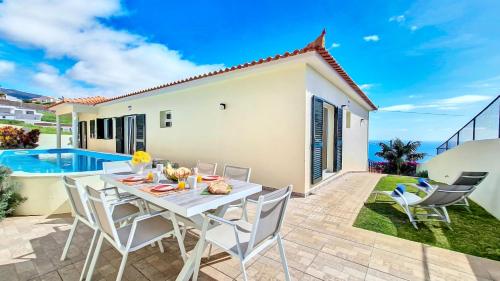 a patio with a table and chairs next to a villa at Casa Eleanor by LovelyStay in Calheta
