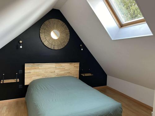 une chambre mansardée avec un lit et un miroir dans l'établissement Gite l'escapade, à Arrest