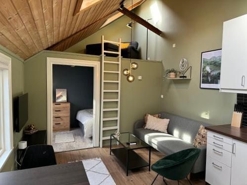 uma sala de estar com um sofá e uma cama alta em Cozy backyard apartment em Trondheim