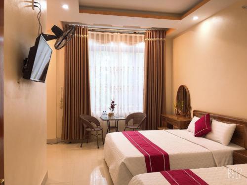 una camera d'albergo con due letti e un tavolo di Khách sạn Hoàng Kiên - Business Hotel a Tuyên Quang