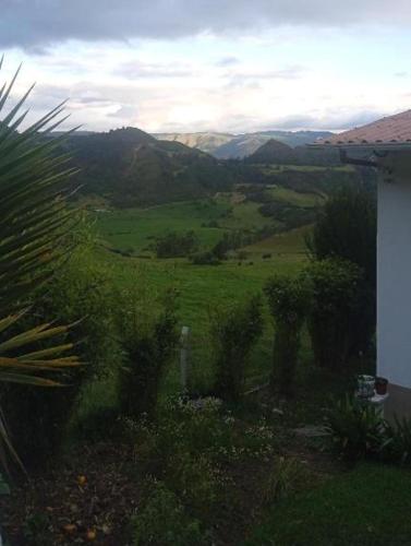a view of a green field with mountains in the background at Vista Hermosa EconoSuite in Turi