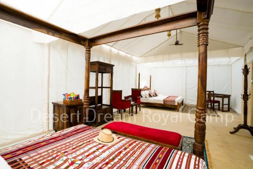 ein Schlafzimmer mit einem Himmelbett und ein Zimmer mit 2 Betten in der Unterkunft Desert Dream Royal Camp with Pool in Jaisalmer
