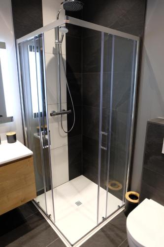 a shower with a glass door in a bathroom at Le Cerf d'Or in Herbeumont