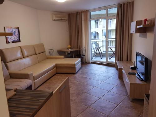 a living room with a couch and a tv at DL Apartments in Aheloy