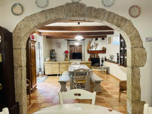 una cucina e una sala da pranzo con arco in pietra di Les Gîtes et la Chambre de Labahou SPA ad Anduze