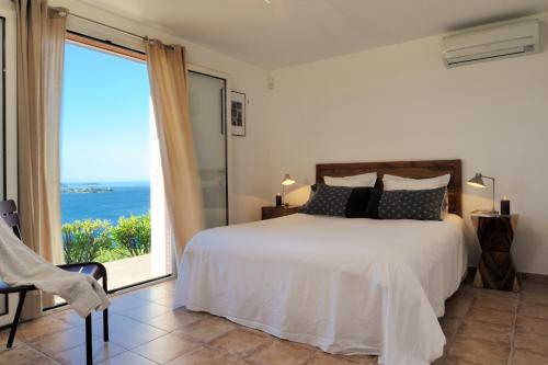 a bedroom with a bed and a view of the ocean at Mini villa Marina Serena in Porto-Vecchio