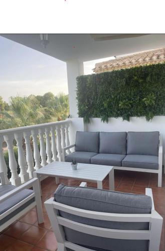 a patio with couches and a table on a balcony at Casa Villamartin Plaza Apartment in Villacosta